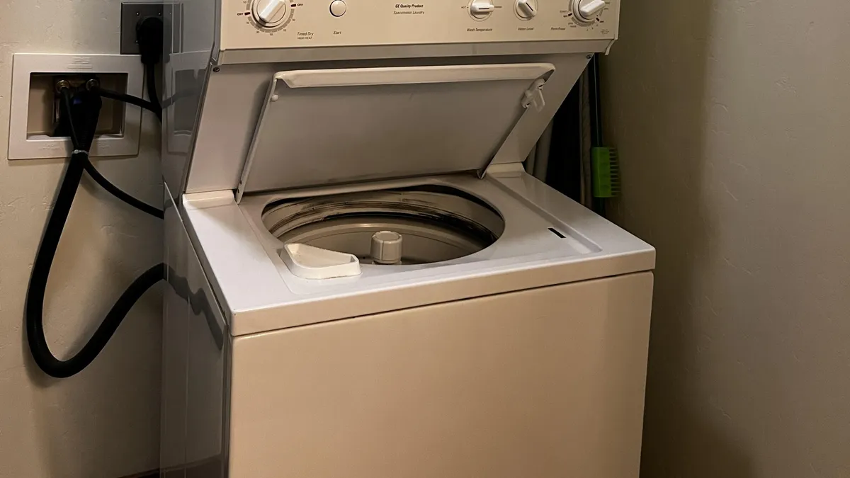A close-up view of a modern washing machine set in a tidy laundry area. The space is practical and well-lit, clearly showcasing in-unit laundry amenities that make day-to-day living more convenient for residents.